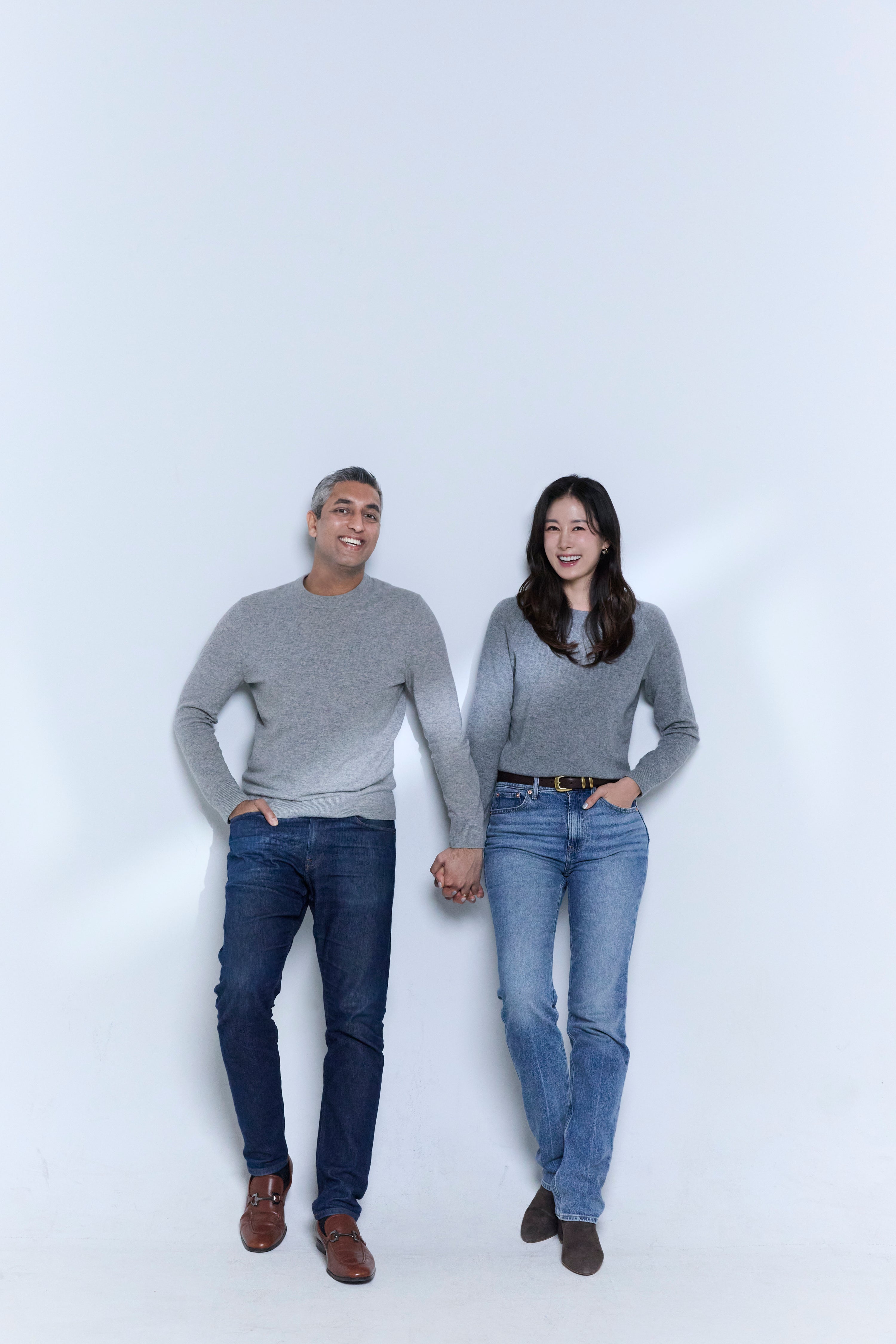 Two people standing side by side on a white background