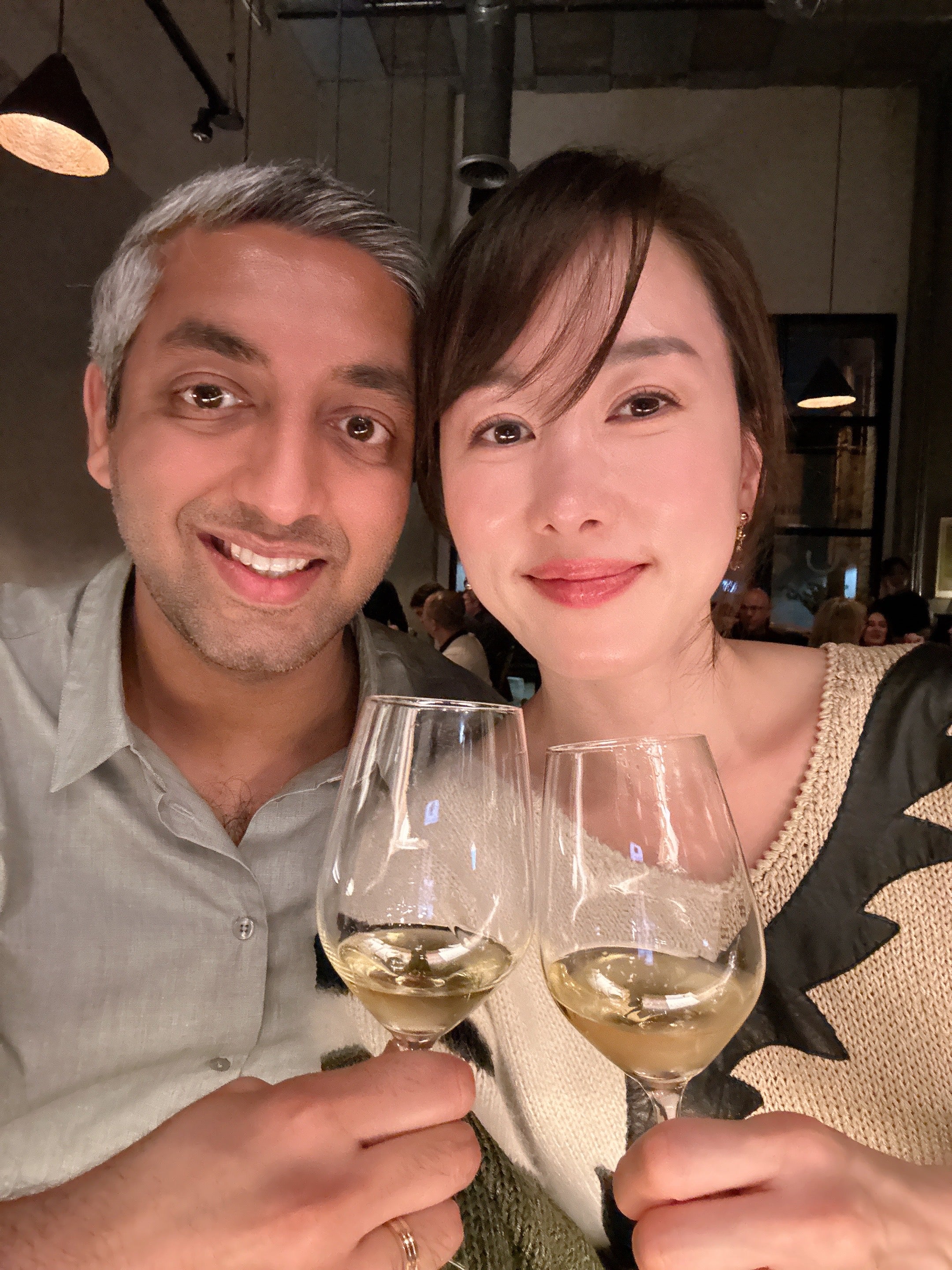 Two people holding wine glasses in a social setting