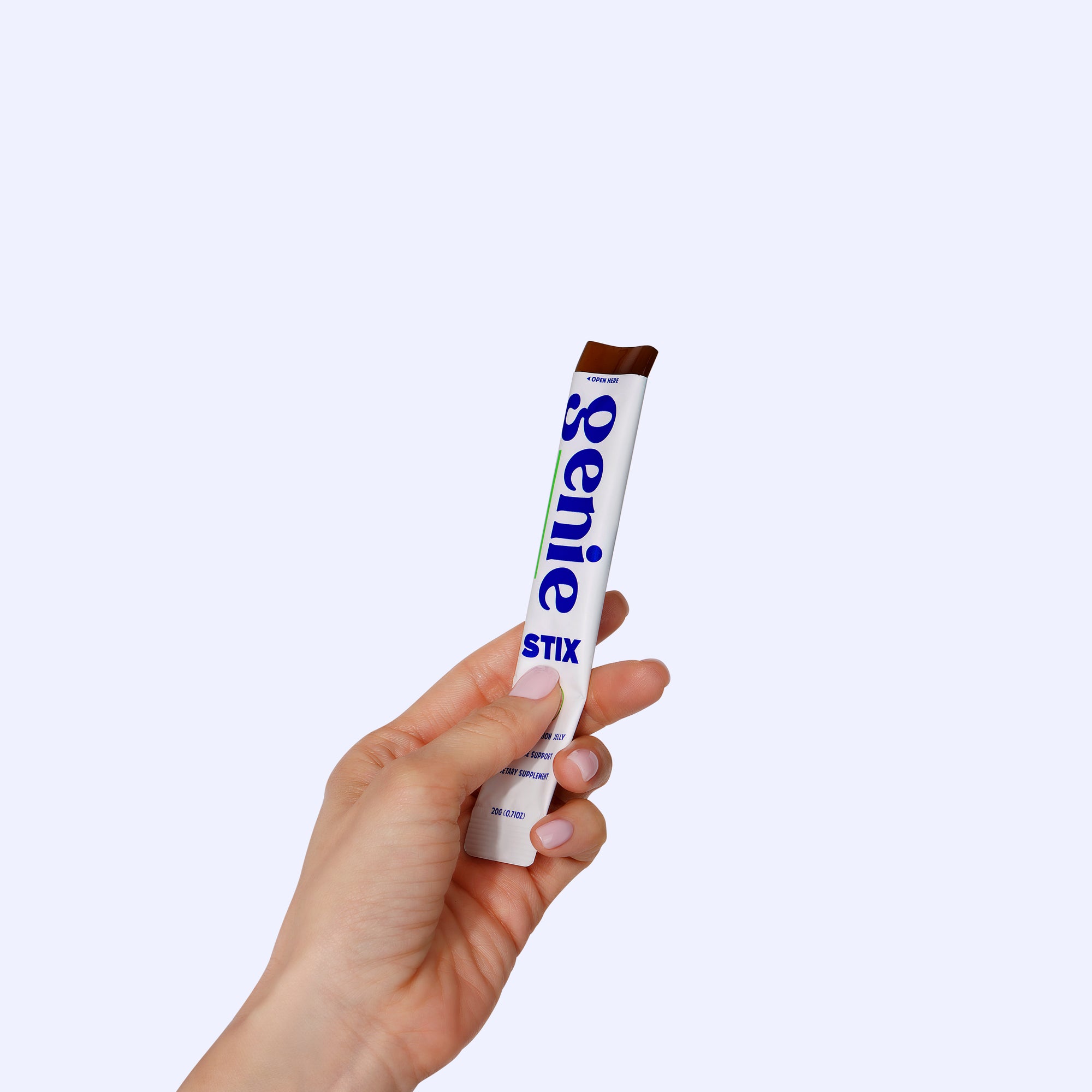 Hand holding a Genie Stix product against a white background