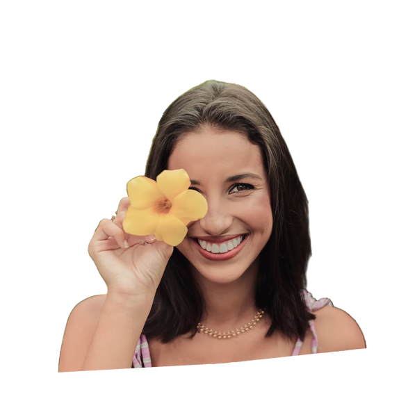 Woman holding a yellow flower to her eye on a white background